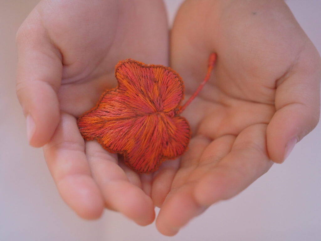 コビトさんの掌の中の紅葉ブローチ。