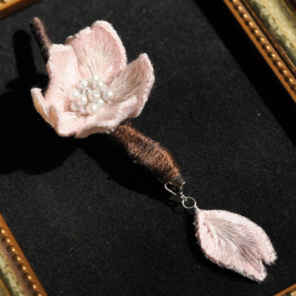 額に乗せたsakuraブローチ。