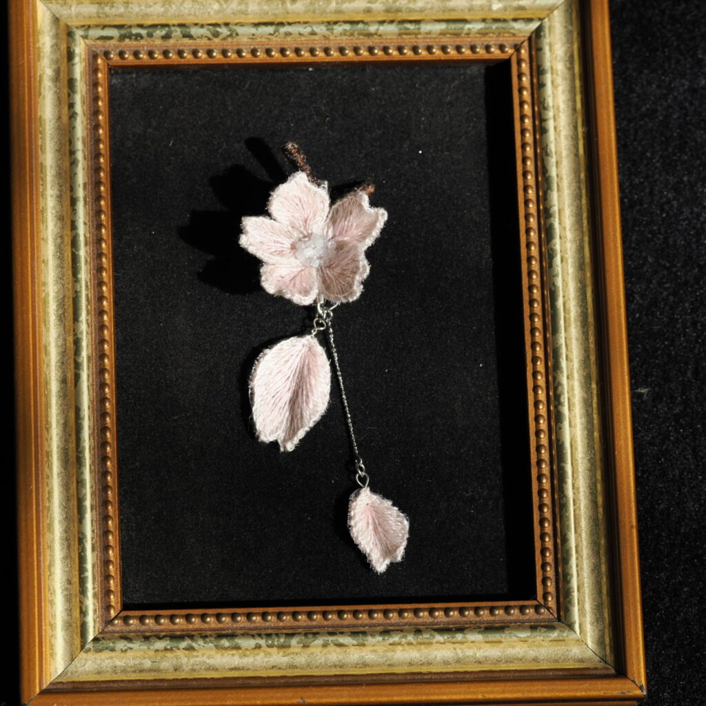 額に乗せたsakuraブローチ。